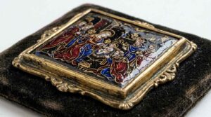 Painted enamel miniature from the Limoges tradition showing deep crimson and gold figures on dark background demonstrating the Purple of Cassius technique